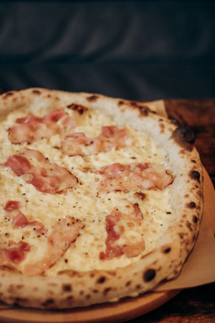 Rapeakuorinen pizza leikattuna puualustalle valmiina nautittavaksi