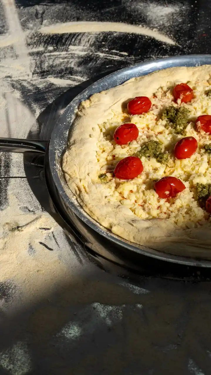 Valmis rapea pizza kirsikkatomaateilla ja tuoreilla yrteillä